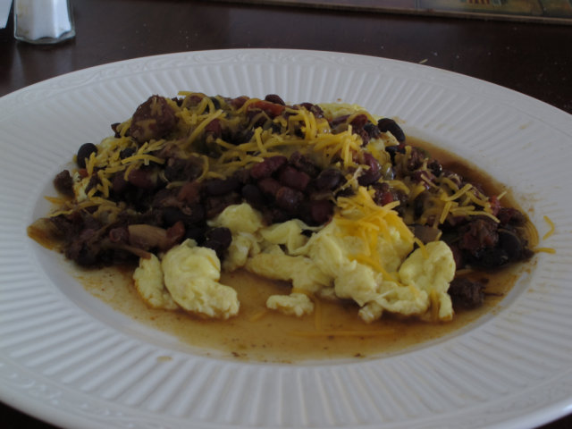 Chili and eggs on a plate, with cheese.