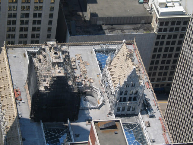 A couple of church looking structures on top of a non-church looking building.