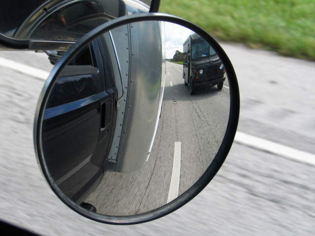 UPS truck in passenger side mirror, moving.