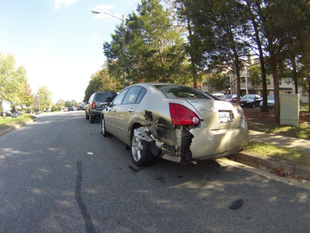 A street parked Maxima that got hit by traffic.